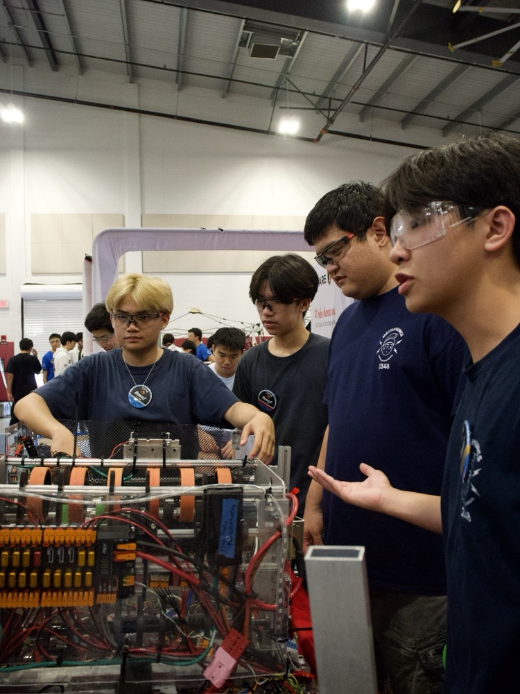 Students working closely with a mentor on a robotics build