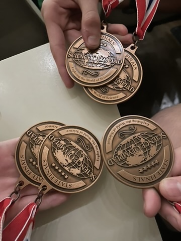 Students holding Science Olympiad medals